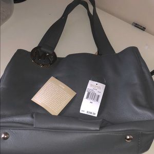 Michael Kors gray purse. light fade on the back of the purse. Included picture.